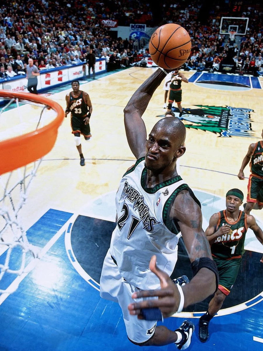 Dynamic action shot of Kevin Garnett soaring for a dunk, showcasing athleticism and intensity.