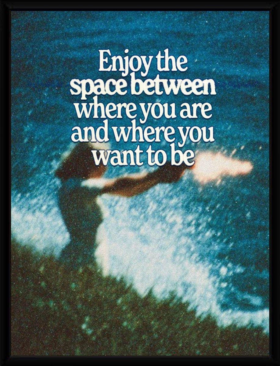 Framed motivational poster showcasing the quote 'Enjoy the space between where you are and where you want to be'.