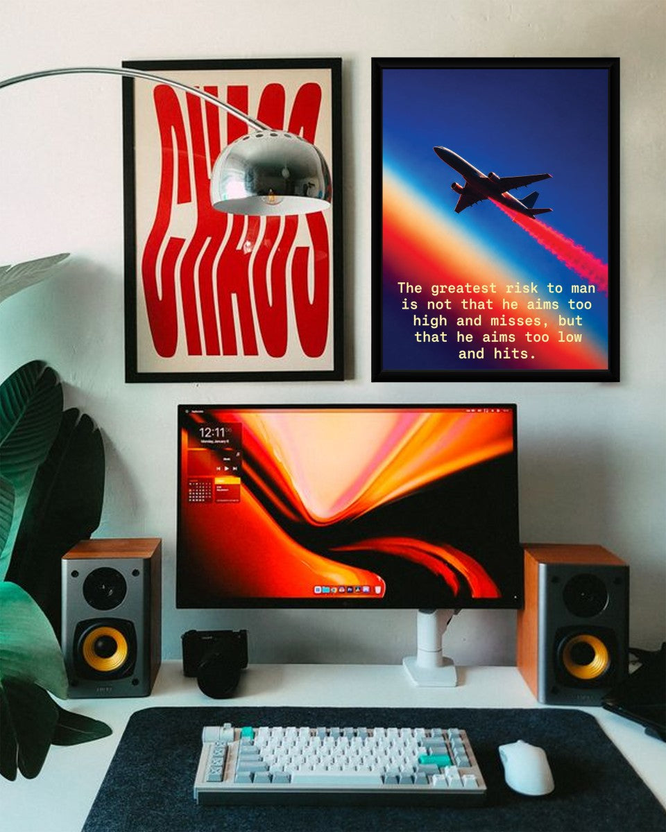 The 'Aim High, Take Risks' poster displayed in a modern styled workspace, adding a touch of inspiration to the room.