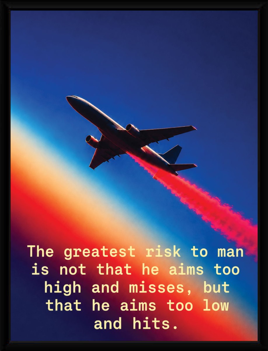 The 'Aim High, Take Risks' poster in a sleek black frame, highlighting its colorful design and inspiring message.