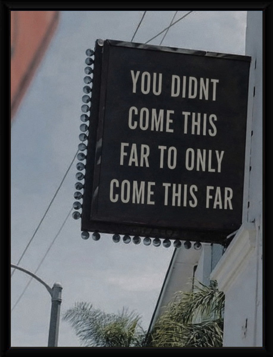 The motivational poster framed, highlighting its bold text and design.