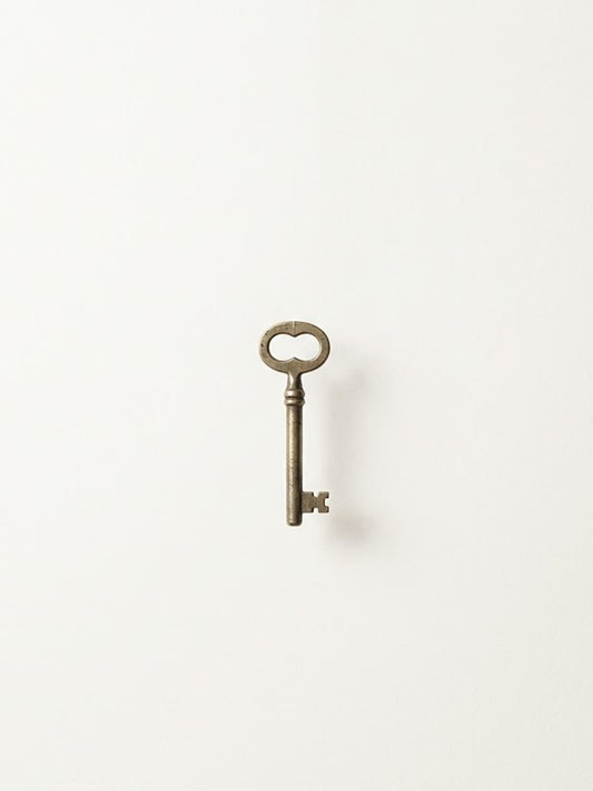 A vintage key poster featuring a detailed brass key on a minimalist white background.
