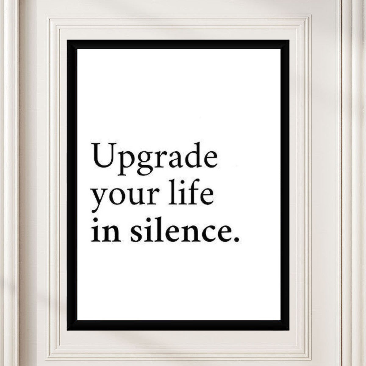 Stylish presentation of the 'Upgrade your life in silence.' poster in a modern workspace.
